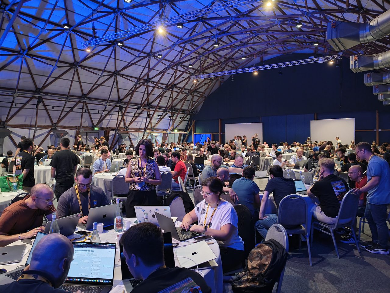 The hackathon hall full of participants working at laptops.